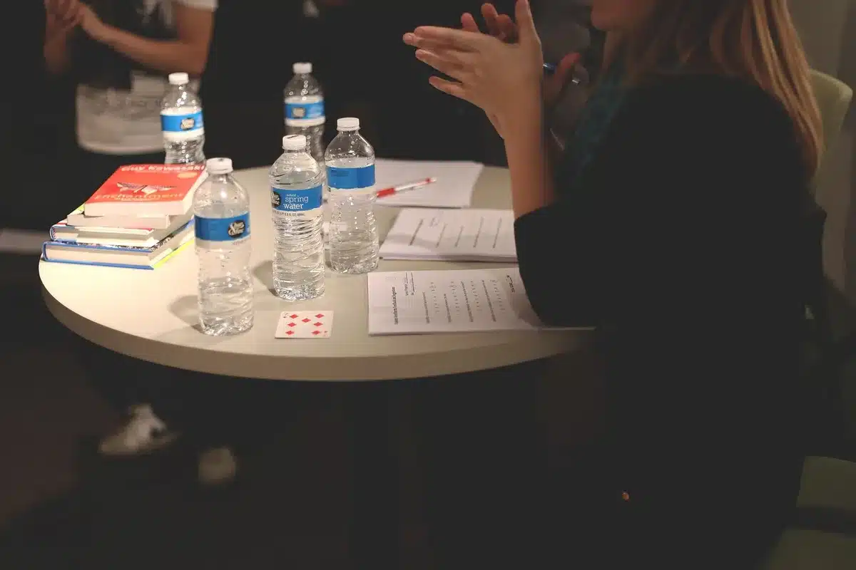 Colleagues around a table using laptops and AI tools in a bright office