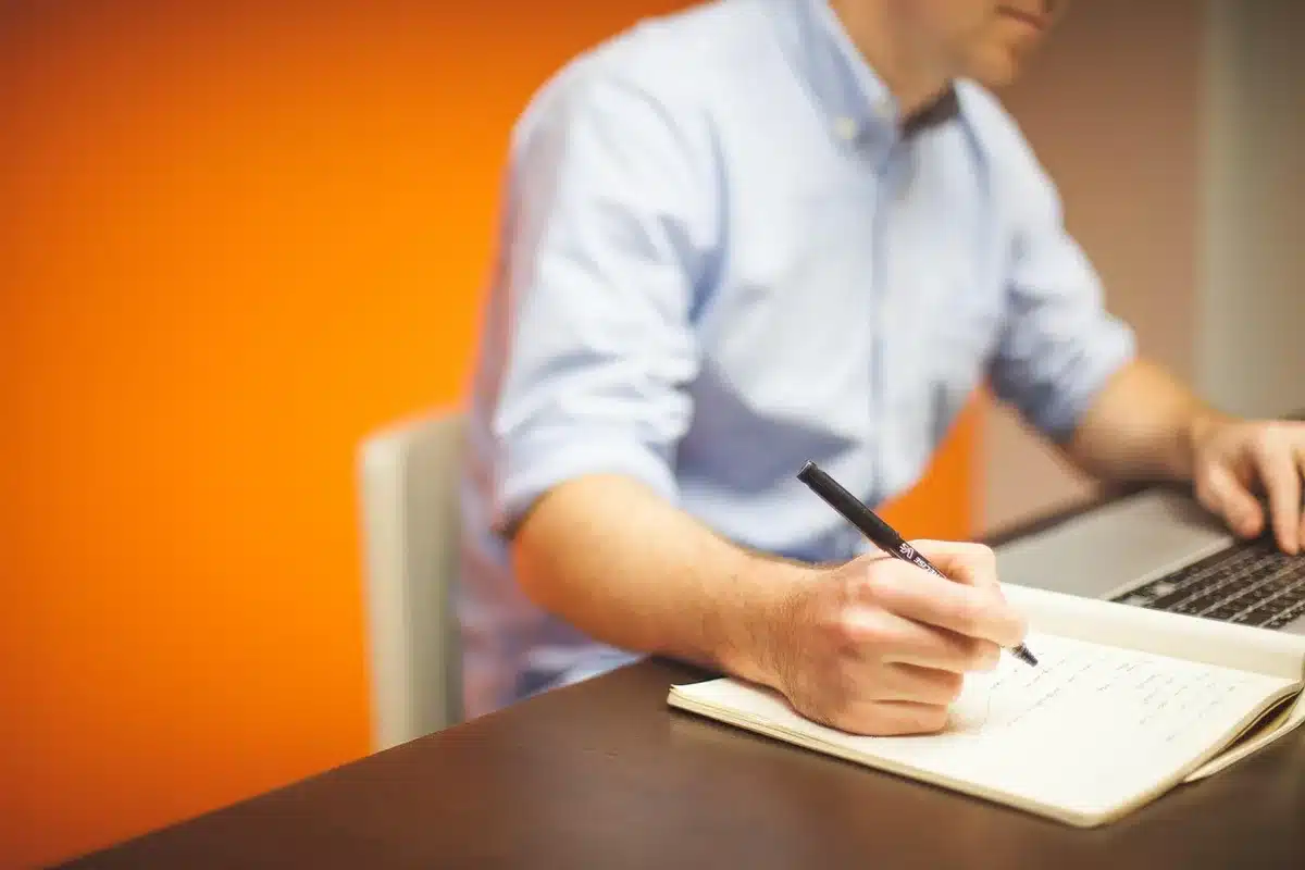 Hands over policy drafts and a laptop on a bright office table