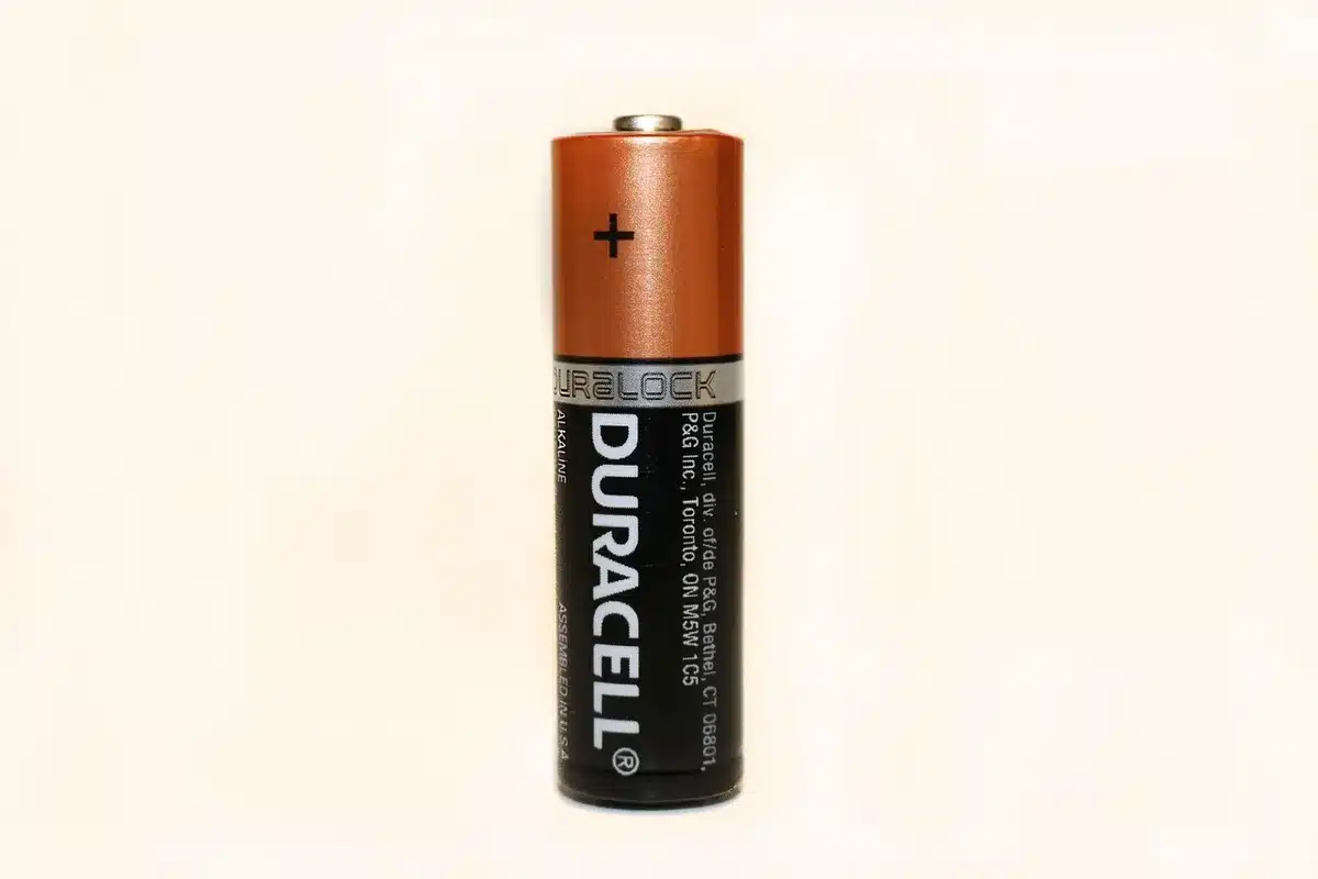 Close-up of a battery cell prototype and electrode components on a lab bench
