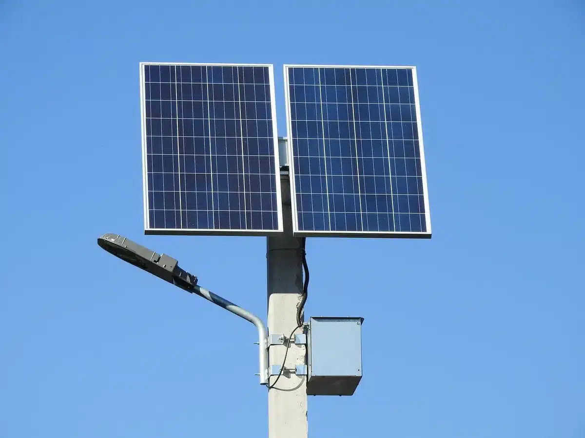 Utility-scale battery storage units near solar panels under clear daylight